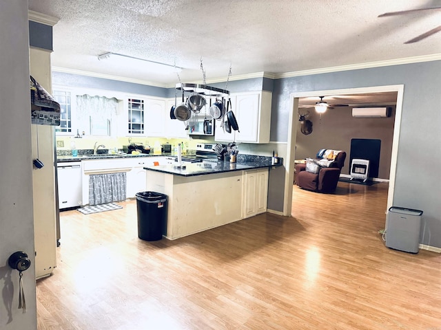 kitchen with ceiling fan, a textured ceiling, appliances with stainless steel finishes, a peninsula, and glass insert cabinets