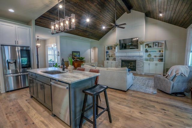 152 Callaway Cir, Hot Springs, AR 71913 - kitchen with stainless steel appliances, open floor plan, light stone counters, a center island with sink, and arched walkways