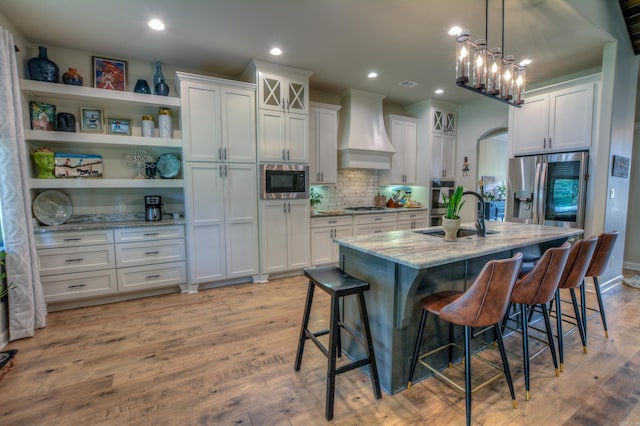 152 Callaway Cir, Hot Springs, AR 71913 - kitchen featuring wall chimney range hood, appliances with stainless steel finishes, light stone counters, a kitchen breakfast bar, and white cabinetry