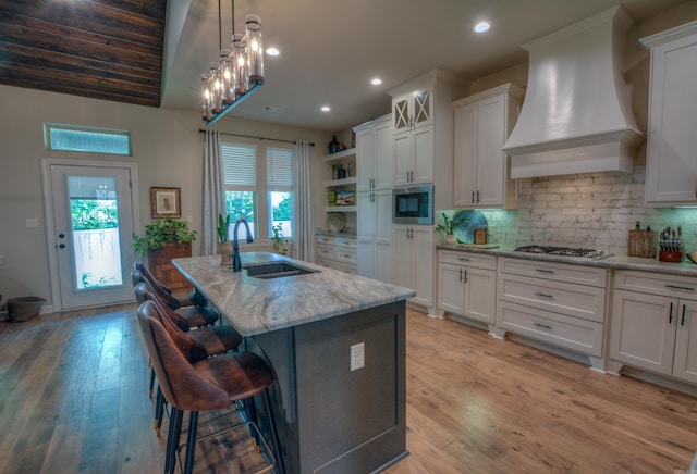 152 Callaway Cir, Hot Springs, AR 71913 - kitchen with wall chimney exhaust hood, stainless steel microwave, white cabinets, open shelves, and light stone counters