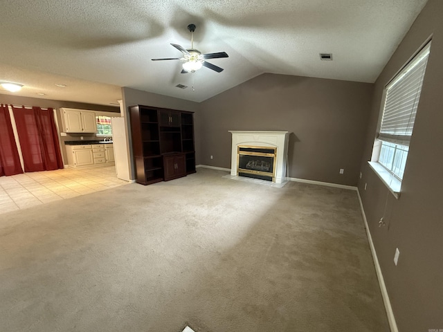 1008 Fox Ridge Dr, Benton, AR 72019 - unfurnished living room with a ceiling fan, lofted ceiling, light carpet, a fireplace with flush hearth, and a textured ceiling