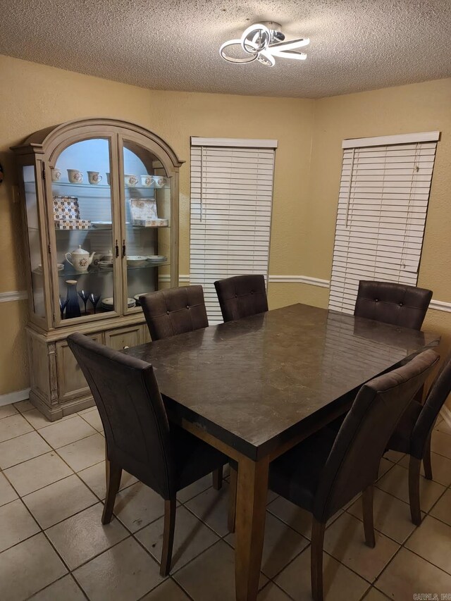 dining room with a textured ceiling and light tile patterned floors