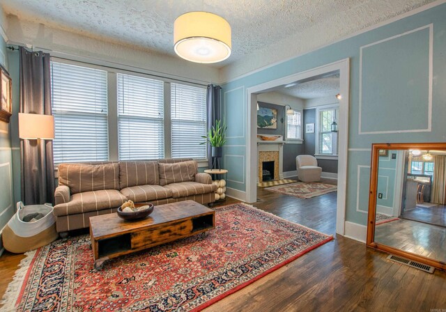 319 W G Ave, North Little Rock, AR 72116 - living area featuring a textured ceiling, wood finished floors, and a tile fireplace