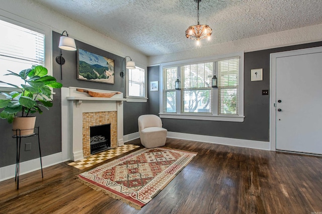 319 W G Ave, North Little Rock, AR 72116 - living room featuring a textured ceiling, hardwood / wood-style floors, a fireplace, and a chandelier