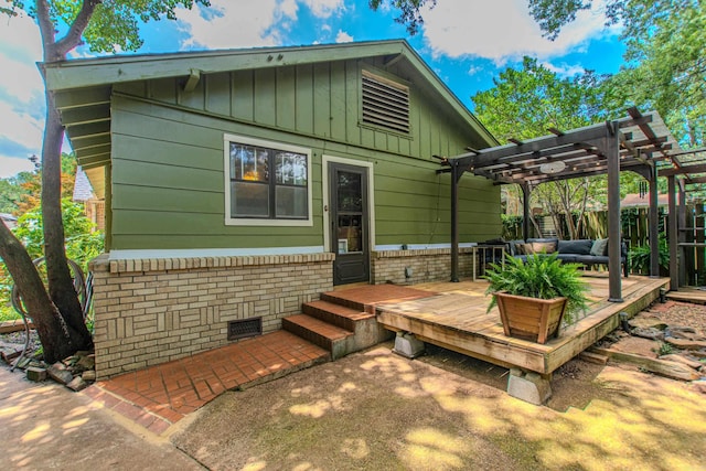 319 W G Ave, North Little Rock, AR 72116 - rear view of property featuring a wooden deck, a pergola, board and batten siding, and an outdoor living space