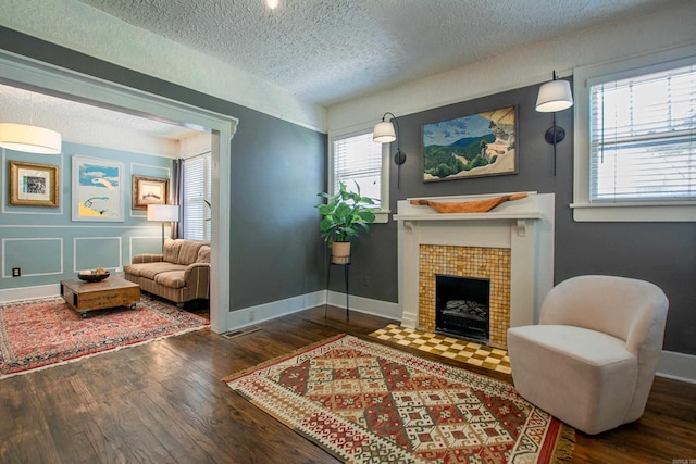 319 W G Ave, North Little Rock, AR 72116 - living area with a textured ceiling, wood finished floors, and a tiled fireplace