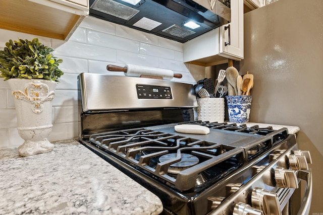 520 E 8th St, Lonoke, AR 72086 - kitchen view of stainless steel gas range, tasteful backsplash, and white cabinetry