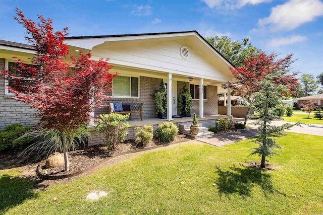 520 E 8th St, Lonoke, AR 72086 - view of front of house with brick siding, a porch, and a front lawn