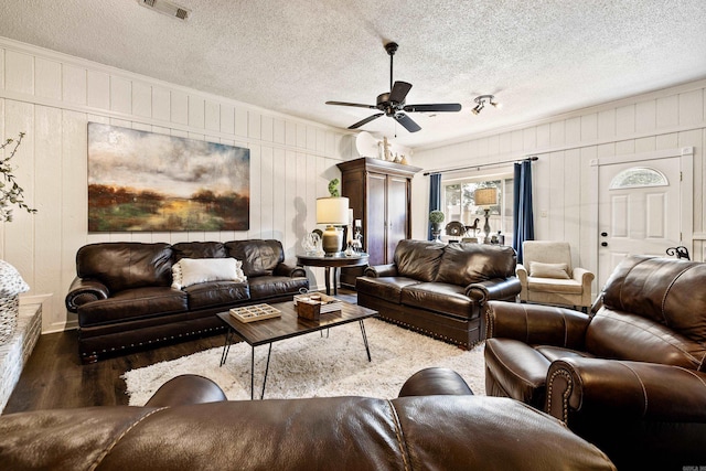520 E 8th St, Lonoke, AR 72086 - living area with wood finished floors, ceiling fan, ornamental molding, wooden walls, and a textured ceiling
