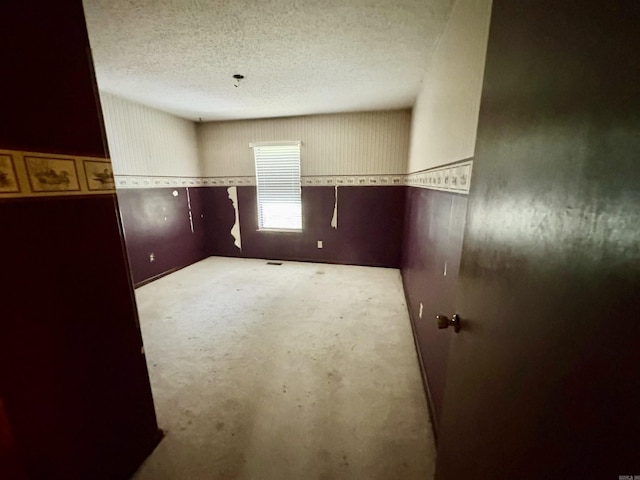 spare room featuring unfinished concrete flooring and a textured ceiling