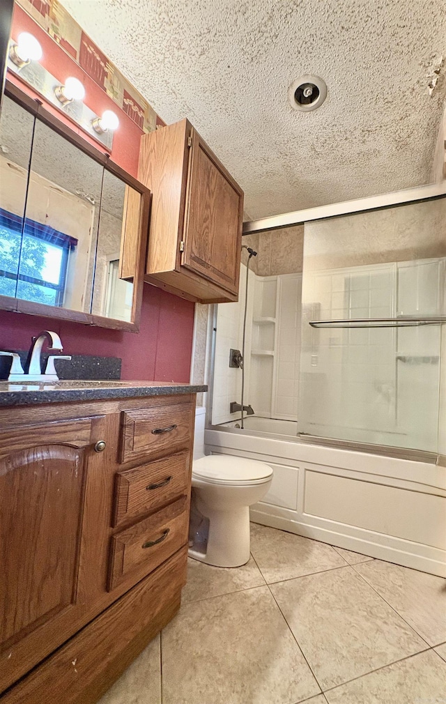 full bath featuring vanity, a textured ceiling, tile patterned floors, and shower / bath combination with glass door