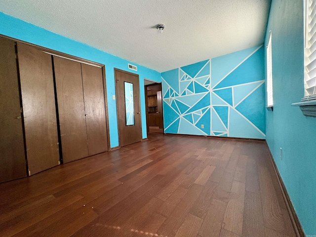 unfurnished bedroom featuring wood finished floors and a textured ceiling