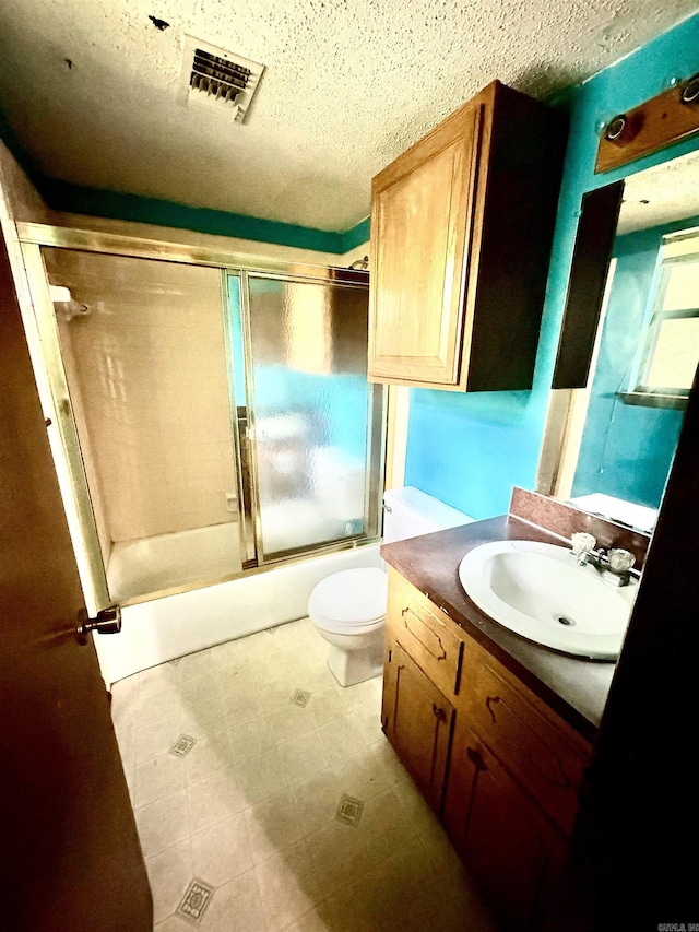 bathroom with vanity, enclosed tub / shower combo, and a textured ceiling
