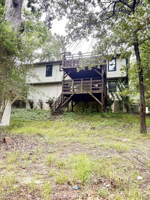 back of house featuring stairs and a deck