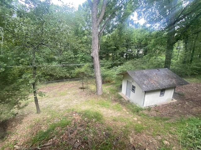 view of yard featuring an outdoor structure and a view of trees