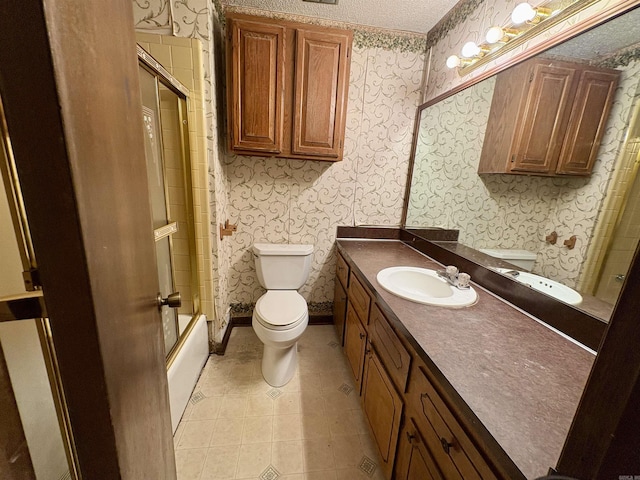 bathroom featuring wallpapered walls, vanity, enclosed tub / shower combo, and tile patterned floors