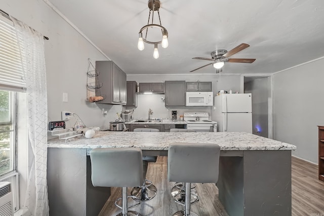 172 Susie Ln, Mena, AR 71953 - kitchen featuring white appliances, gray cabinetry, a peninsula, a kitchen bar, and ceiling fan