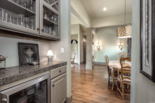 12 Cobblestone Way, Little Rock, AR 72223 - indoor dry bar featuring wine cooler, wood finished floors, decorative columns, decorative light fixtures, and recessed lighting