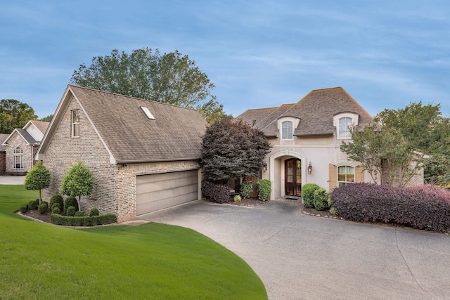 12 Cobblestone Way, Little Rock, AR 72223 - french country inspired facade featuring concrete driveway, a front yard, brick siding, a shingled roof, and stucco siding
