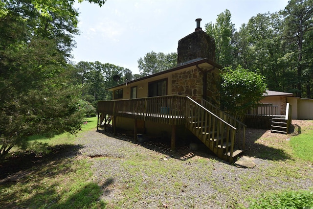 230 Spring St, Fairfield Bay, AR 72088 - back of house featuring stairs, a chimney, a deck, and stone siding