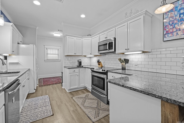 100 Melrose Dv, North Little Rock, AR 72114 - kitchen with stainless steel appliances, white cabinetry, light wood-style floors, dark stone counters, and ornamental molding