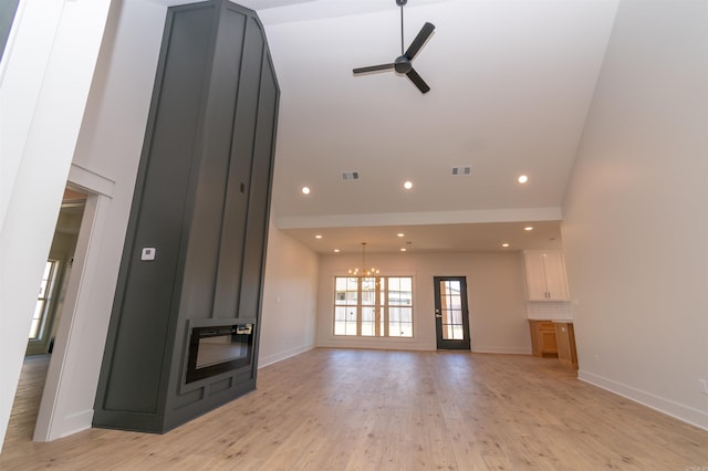 2284 Sistine Chapel Cir, Jonesboro, AR 72404 - unfurnished living room featuring a ceiling fan, a chandelier, light wood-style flooring, recessed lighting, and a high ceiling