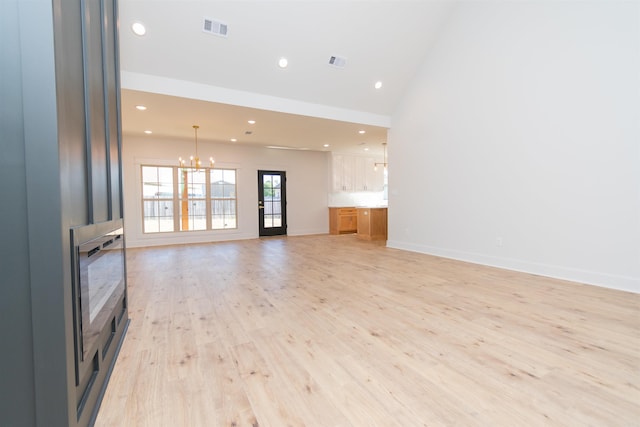 2284 Sistine Chapel Cir, Jonesboro, AR 72404 - unfurnished living room with a chandelier, recessed lighting, light wood finished floors, and vaulted ceiling