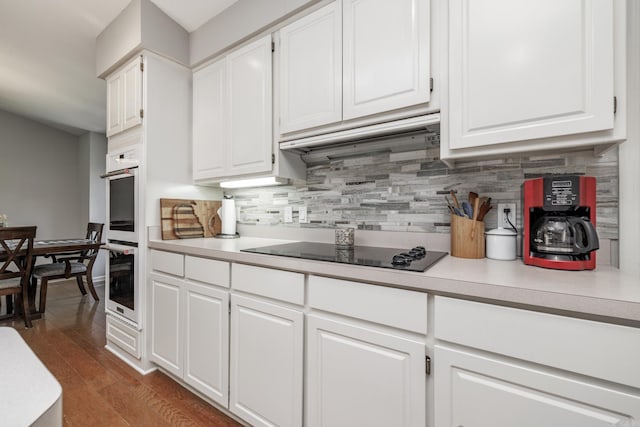 96 San Sebastian Way, Hot Springs Village, AR 71909 - kitchen with black electric stovetop, double oven, decorative backsplash, and white cabinets