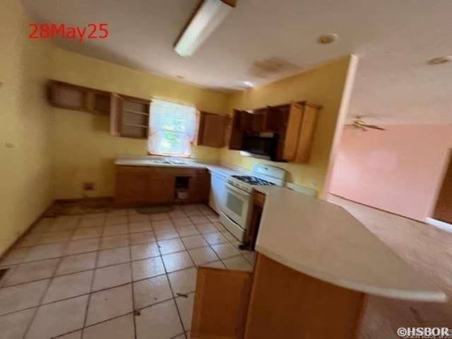 1116 Mccracken Ridge Rd, Mountain Home, AR 72653 - kitchen with gas range gas stove, light countertops, brown cabinetry, and light tile patterned floors