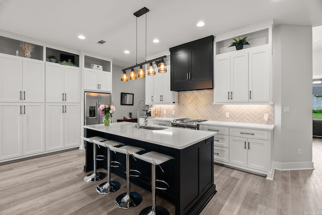 127 Copper Cir, Little Rock, AR 72223 - kitchen with stainless steel appliances, light wood-type flooring, tasteful backsplash, light countertops, and a center island with sink