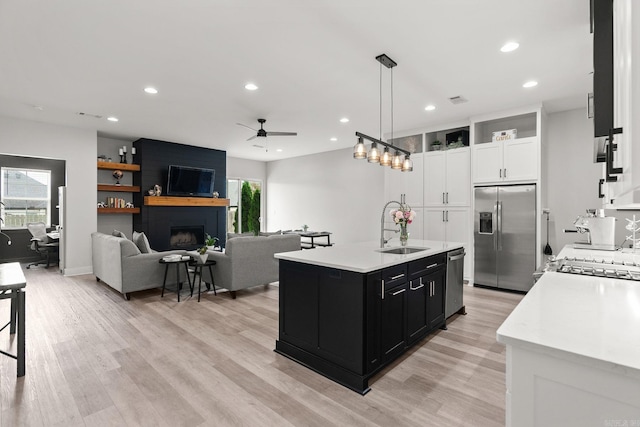127 Copper Cir, Little Rock, AR 72223 - kitchen with appliances with stainless steel finishes, dark cabinets, light countertops, ceiling fan, and white cabinets