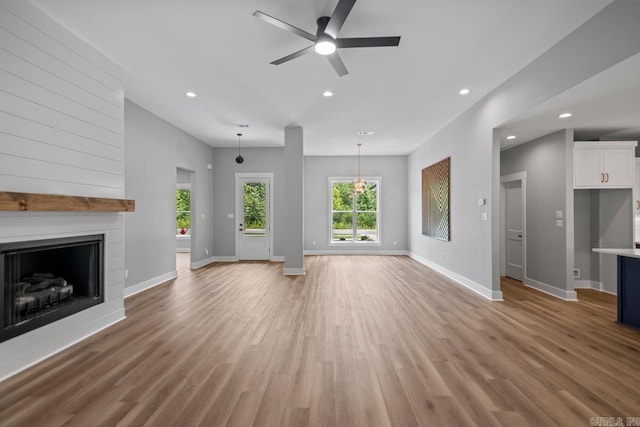 6185 Creekwater, Bryant, AR 72002 - unfurnished living room with a fireplace, light wood-type flooring, ceiling fan, and recessed lighting