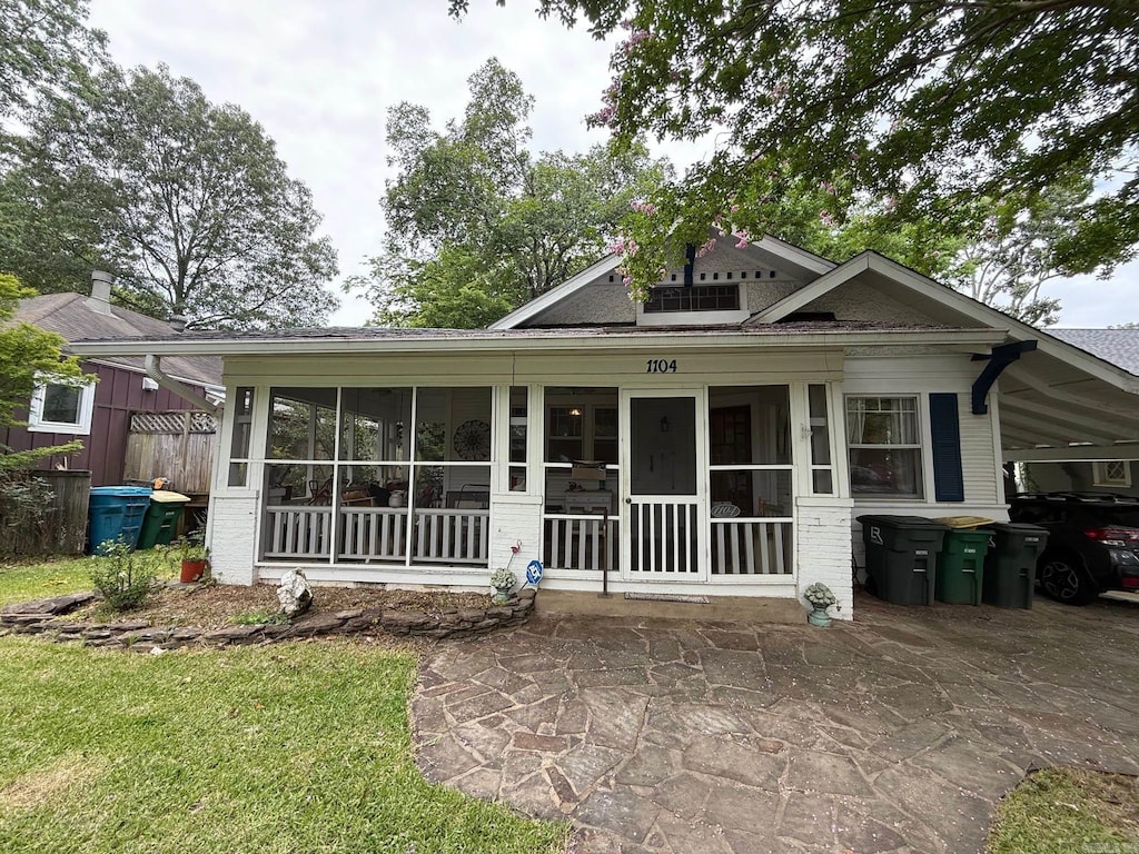 1104 N Monroe St, Little Rock, AR 72205 - view of front of property with a sunroom, brick siding, and an attached carport