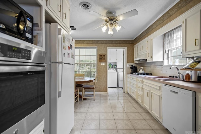 11414 E Stoney Point Ct, Little Rock, AR 72211 - kitchen with appliances with stainless steel finishes, ornamental molding, a ceiling fan, washing machine and dryer, and light tile patterned flooring