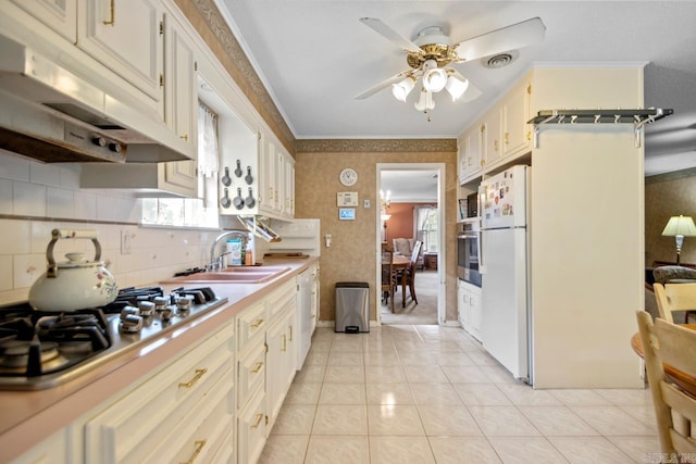 11414 E Stoney Point Ct, Little Rock, AR 72211 - kitchen featuring appliances with stainless steel finishes, under cabinet range hood, ceiling fan, light tile patterned flooring, and ornamental molding