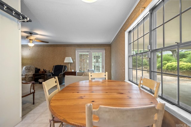 11414 E Stoney Point Ct, Little Rock, AR 72211 - dining area with wallpapered walls, a ceiling fan, tile patterned flooring, and a textured ceiling