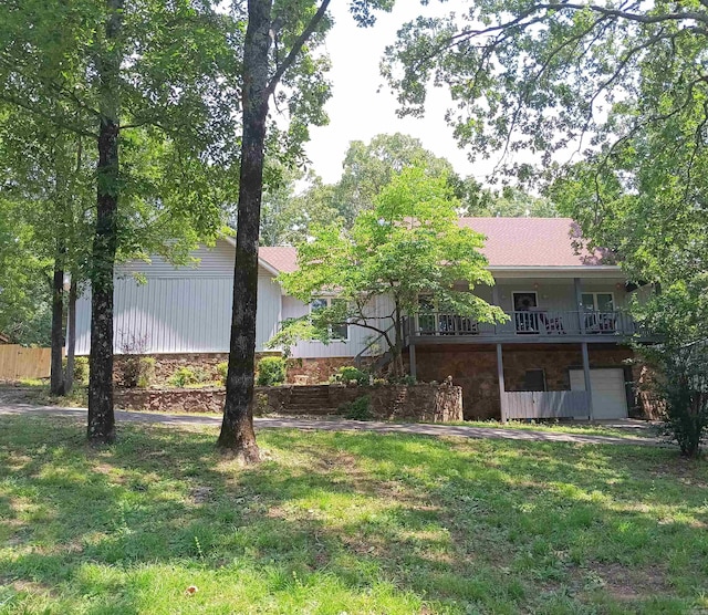 1402 Holmes Rd, Searcy, AR 72143 - rear view of house featuring an attached garage, a lawn, and stone siding