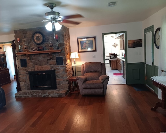 1402 Holmes Rd, Searcy, AR 72143 - living room featuring a ceiling fan, wood finished floors, a wainscoted wall, and a fireplace