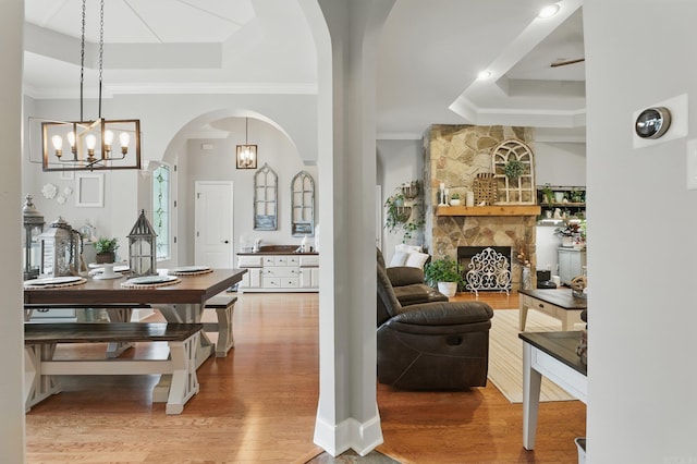 3051 Mount Mcgregor Dr, Benton, AR 72019 - dining room with a tray ceiling, wood finished floors, ornamental molding, a chandelier, and arched walkways