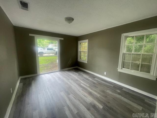 741 Macarthur Ave, Wake Village, TX 75501 - empty room with a textured ceiling and wood finished floors