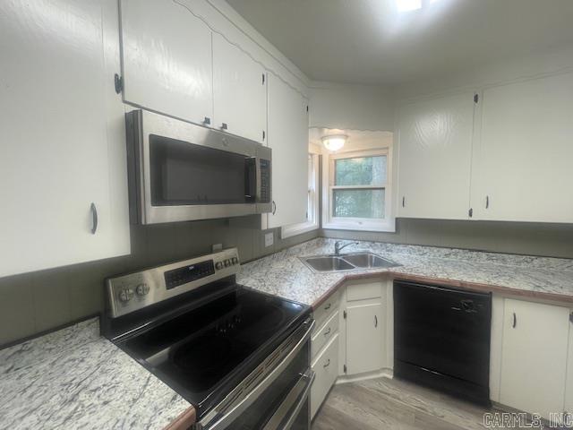 741 Macarthur Ave, Wake Village, TX 75501 - kitchen featuring appliances with stainless steel finishes, light countertops, white cabinetry, and light wood-style flooring