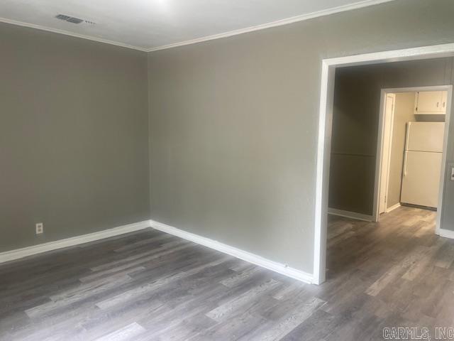 741 Macarthur Ave, Wake Village, TX 75501 - spare room featuring ornamental molding and dark wood finished floors