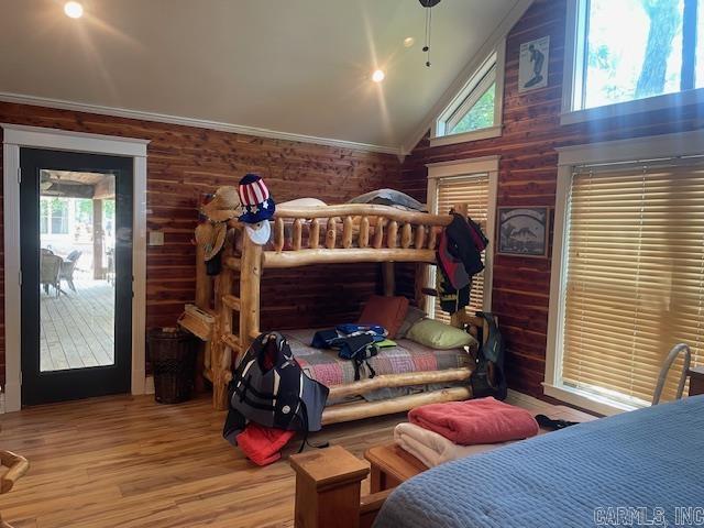 bedroom with wood finished floors and high vaulted ceiling