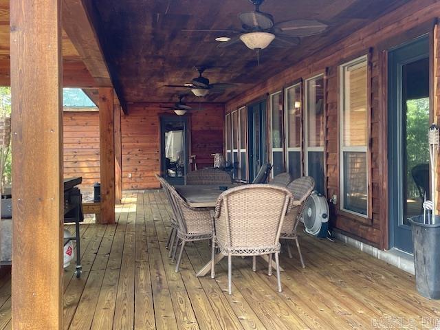 wooden terrace featuring a ceiling fan and outdoor dining area