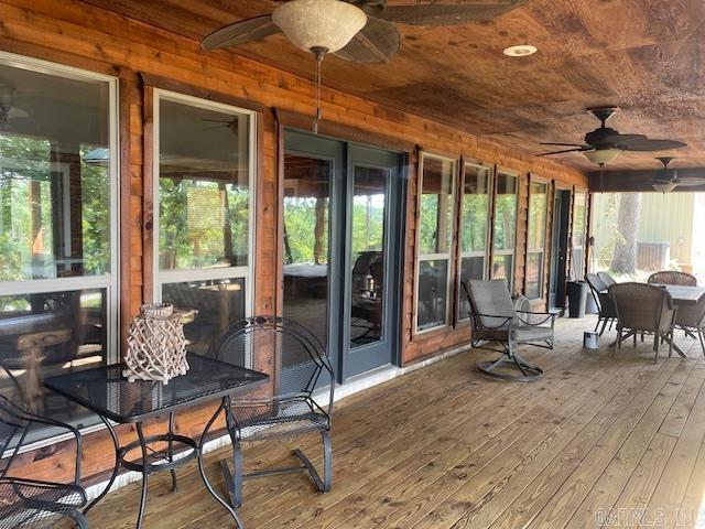 sunroom / solarium featuring ceiling fan, outdoor dining space, and healthy amount of natural light