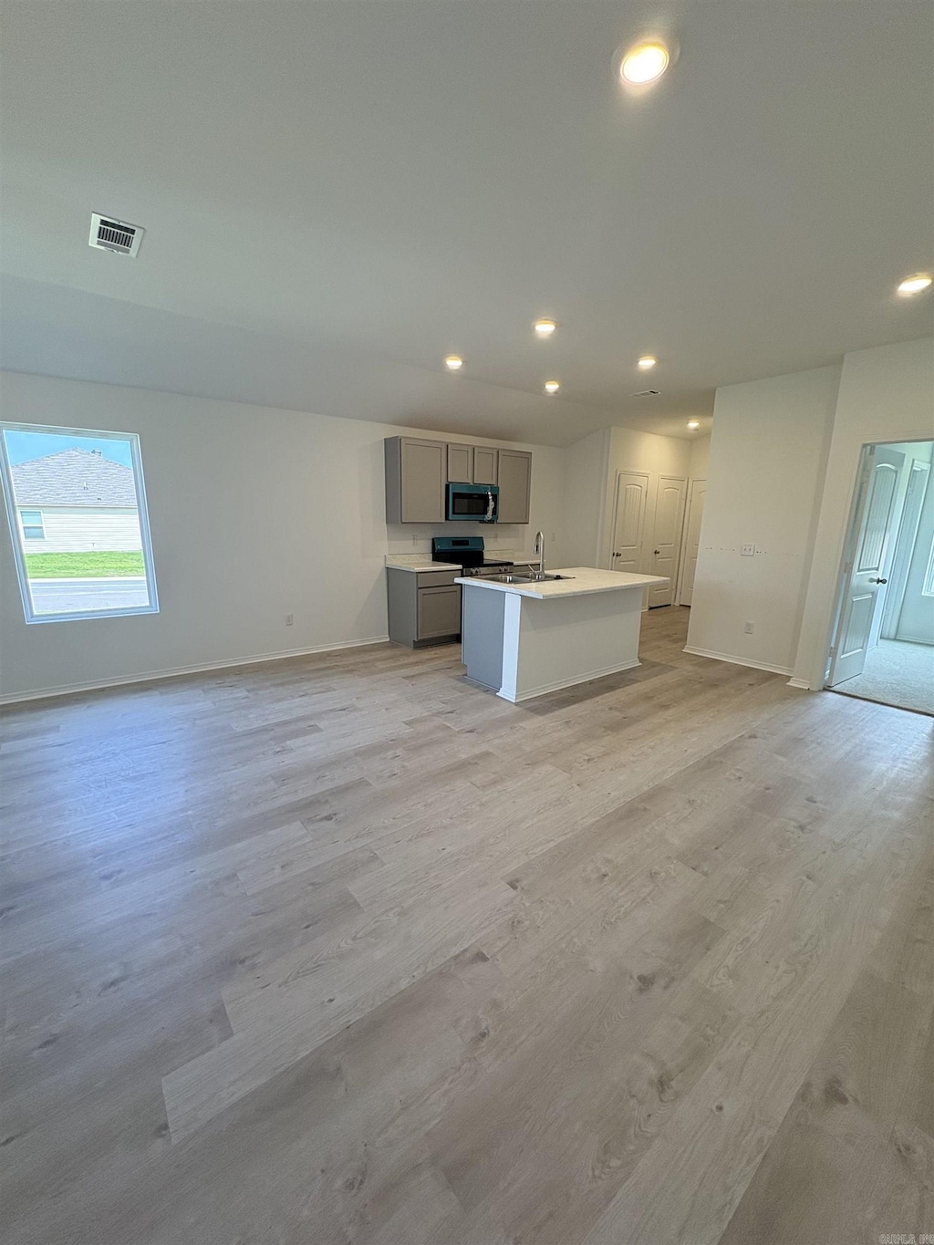 6089 Croft Ave, Benton, AR 72019 - kitchen with appliances with stainless steel finishes, gray cabinetry, a center island with sink, light wood finished floors, and recessed lighting