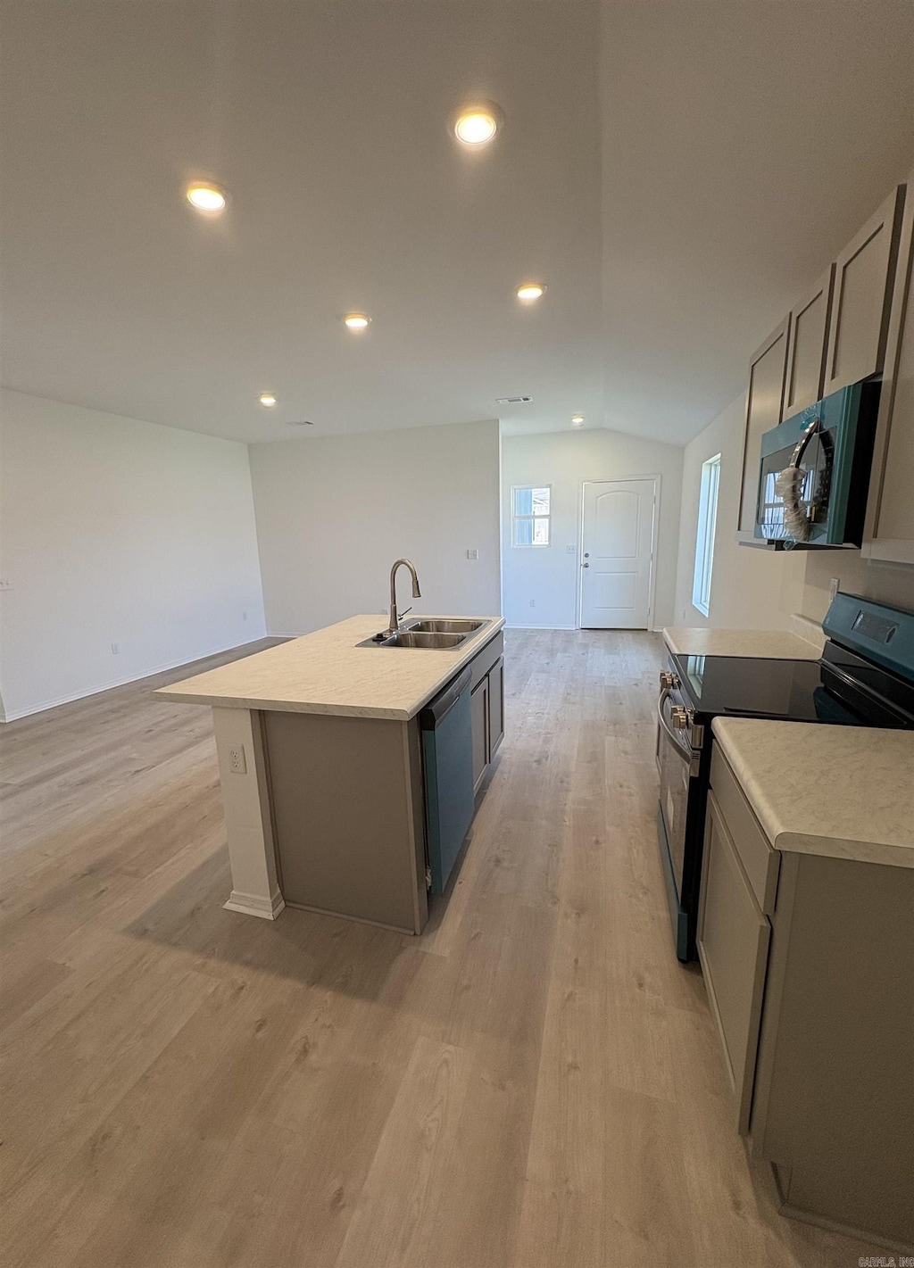 6089 Croft Ave, Benton, AR 72019 - kitchen featuring stainless steel appliances, a kitchen island with sink, light countertops, light wood-type flooring, and vaulted ceiling