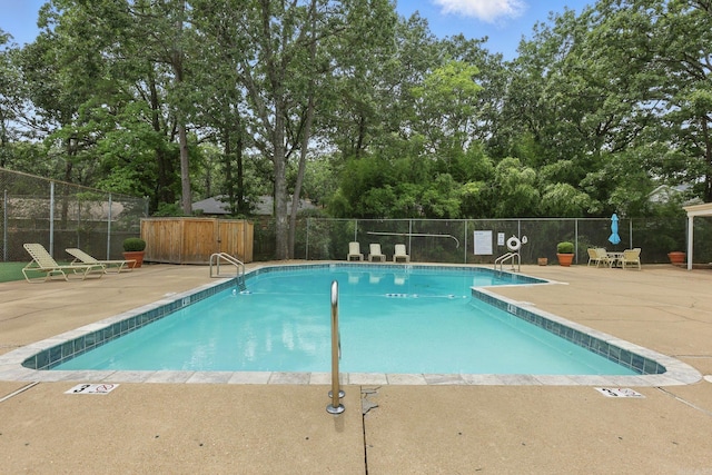 49 Kingsbridge Way, Little Rock, AR 72212 - community pool featuring a patio area and view of wooded area