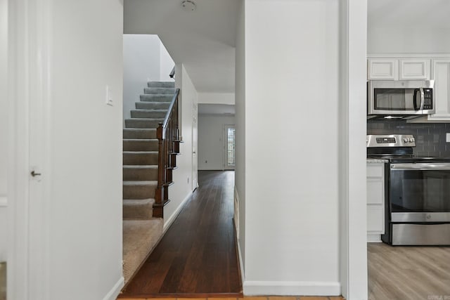 49 Kingsbridge Way, Little Rock, AR 72212 - kitchen featuring stainless steel appliances, light wood-type flooring, white cabinets, and decorative backsplash