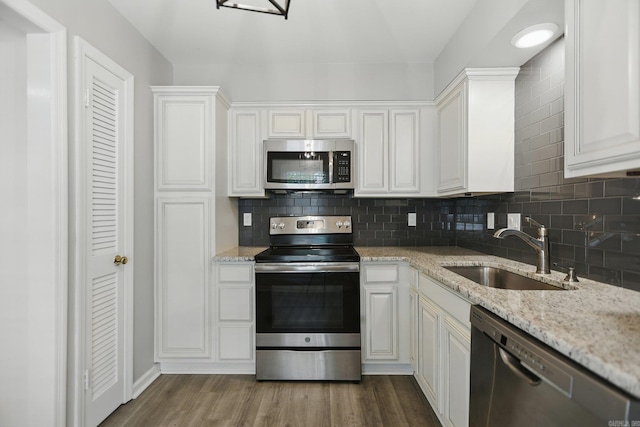 49 Kingsbridge Way, Little Rock, AR 72212 - kitchen with appliances with stainless steel finishes, white cabinets, decorative backsplash, dark wood-type flooring, and light stone countertops